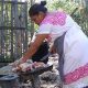 Maya-Frau zerteilt totes Huhn in ihrem Garten