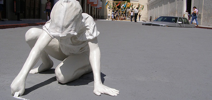 Müllskulptur Kind malt mit Kreide auf Straße